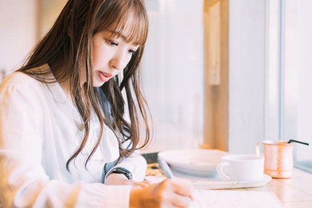 カフェで勉強する若い女性