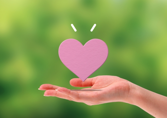 女性の手とハート