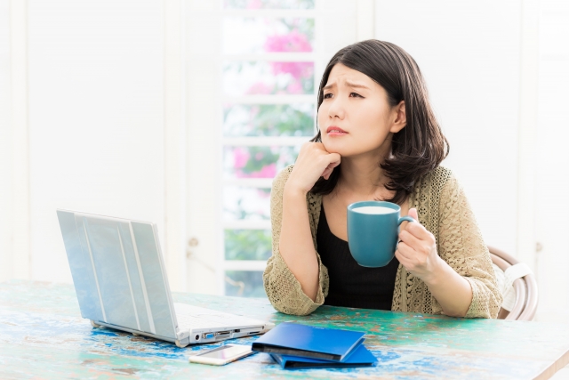 パソコンを前に悩む女性